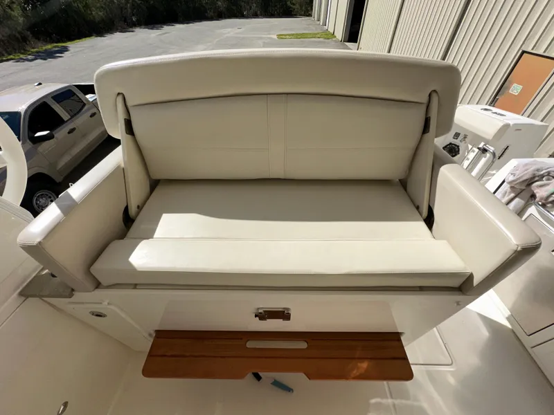 Slide: The Image of 2021 Boston Whaler Realm 380 boat seat with white upholstery and wooden accents. - 35