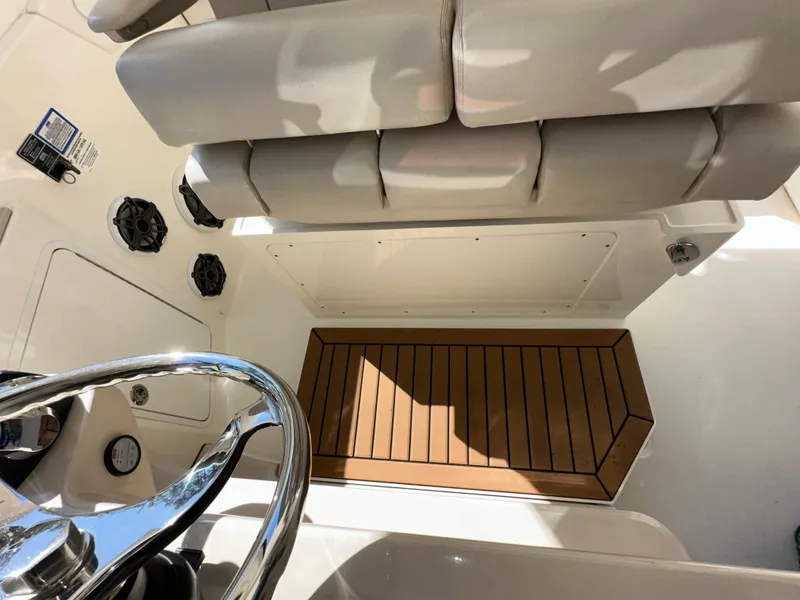 Slide: The Image of 2021 Boston Whaler Realm 380 helm area with cushioned seating and wooden flooring. - 38