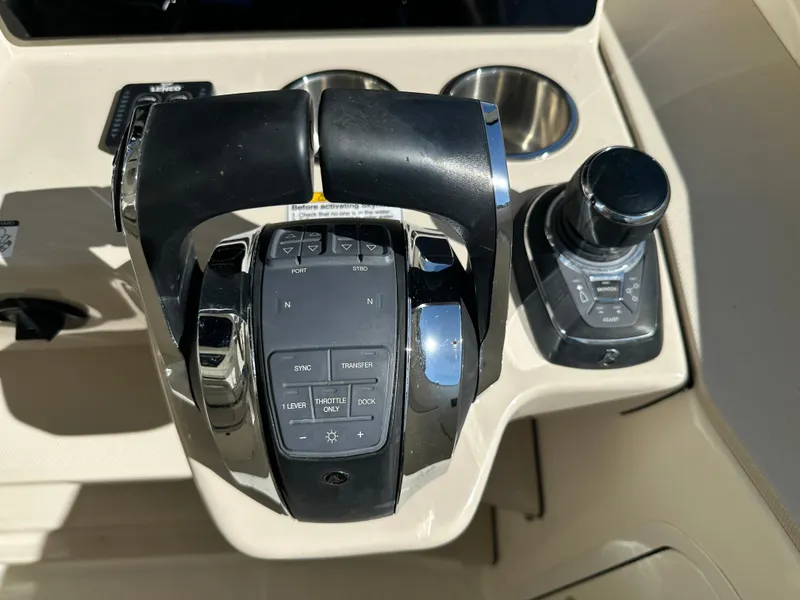 Slide: The Image of Control panel of a 2021 Boston Whaler Realm 380 boat, featuring throttle and joystick. - 48