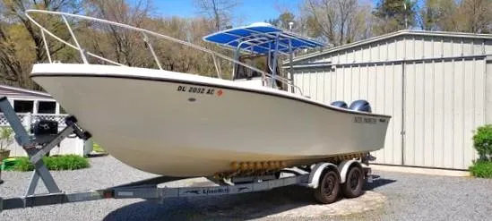 Slide: The Image of 1990 Mako 261 Center Console boat on trailer, parked outdoors. - 1