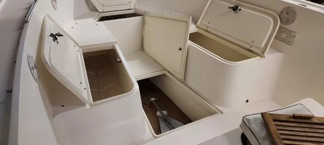 Slide: The Image of 1990 Mako 261 Center Console boat storage compartments open for viewing. - 10