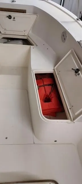 Slide: The Image of 1990 Mako 261 Center Console boat with open storage compartments and visible life jackets. - 11