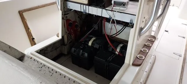 Slide: The Image of 1990 Mako 261 Center Console boat battery compartment with wiring and storage. - 16