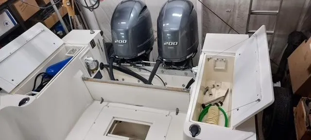 Slide: The Image of 1990 Mako 261 Center Console boat with dual 200 horsepower engines, open storage compartments. - 18