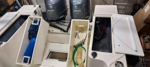 Slide: The Image of 1990 Mako 261 Center Console boat with dual 200 horsepower engines, open storage compartments. - 19