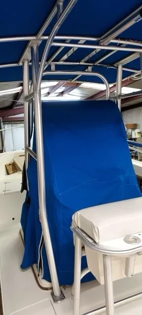 Slide: The Image of 1990 Mako 261 Center Console boat with blue cover and T-top frame. - 5