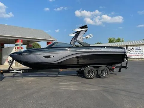 Slide: The Image of 2019 Centurion Ri237 boat on trailer, parked outdoors under a clear blue sky. - 0