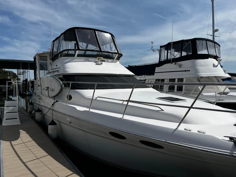Slide: The Image of 2001 Sea Ray 420 Aft Cabin yacht docked at marina under clear sky. - 0