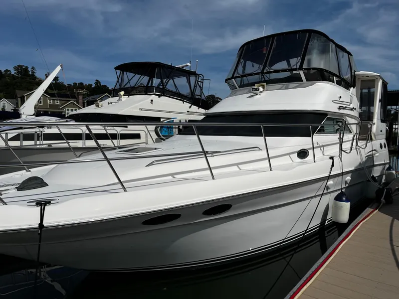 Slide: The Image of 2001 Sea Ray 420 Aft Cabin yacht docked at marina under clear sky. - 1