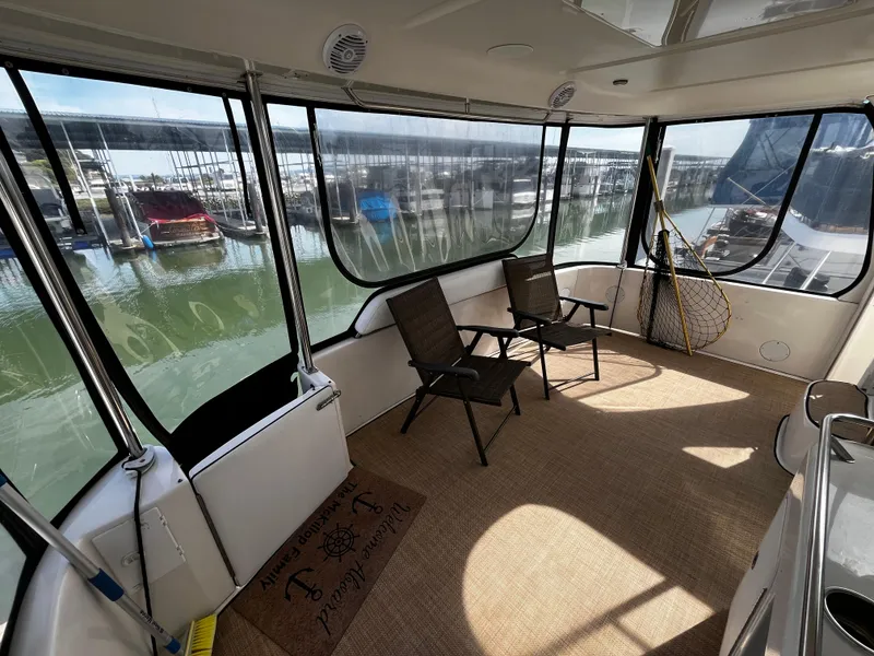 Slide: The Image of 2001 Sea Ray 420 Aft Cabin interior with chairs, overlooking marina. - 11