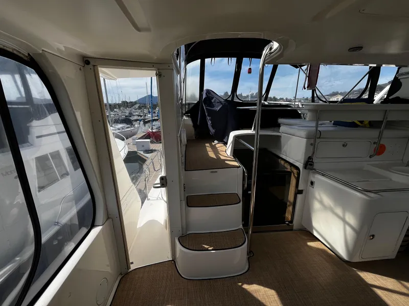 Slide: The Image of Interior view of 2001 Sea Ray 420 Aft Cabin yacht with stairs and marina backdrop. - 12