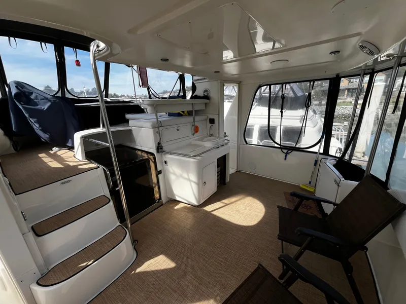 Slide: The Image of 2001 Sea Ray 420 Aft Cabin interior with seating, stairs, and windows. - 13