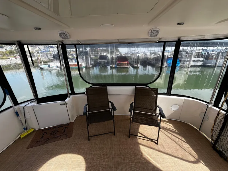 Slide: The Image of 2001 Sea Ray 420 Aft Cabin interior with two chairs overlooking marina. - 14