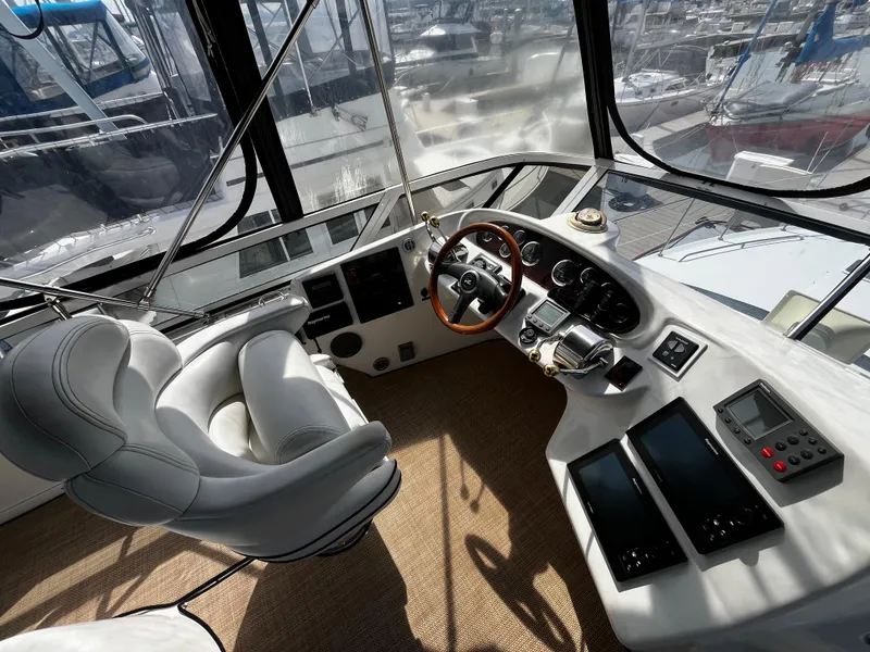 Slide: The Image of Helm of 2001 Sea Ray 420 Aft Cabin yacht with modern controls and leather seating. - 16