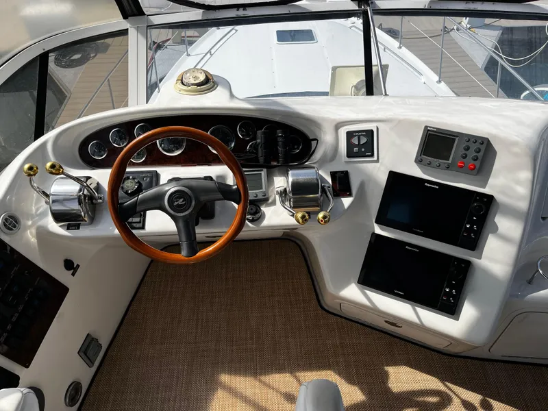 Slide: The Image of 2001 Sea Ray 420 Aft Cabin helm with wood steering wheel and navigation instruments. - 17