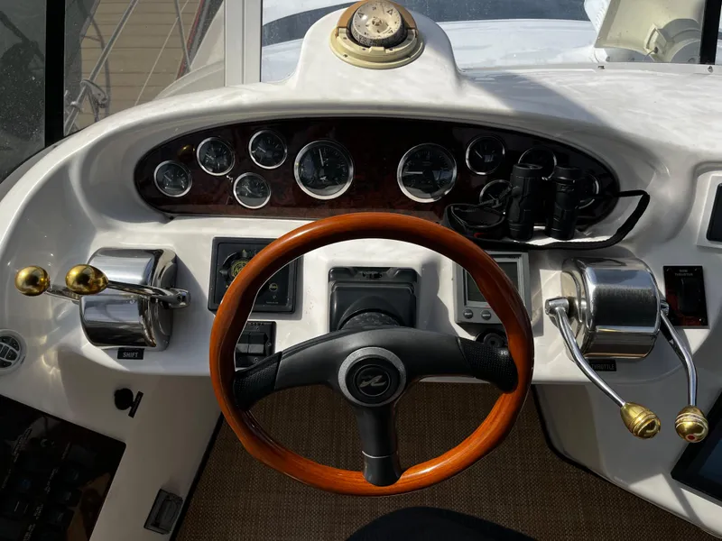 Slide: The Image of Helm of 2001 Sea Ray 420 Aft Cabin with wooden steering wheel and control panel. - 18
