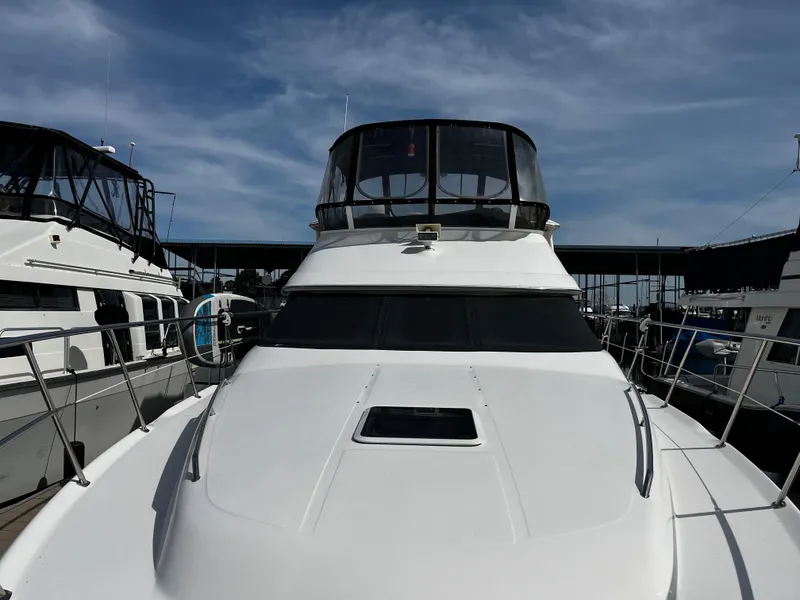 Slide: The Image of 2001 Sea Ray 420 Aft Cabin yacht docked under clear sky. - 2