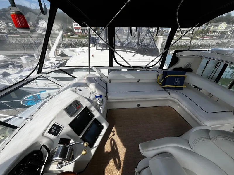 Slide: The Image of 2001 Sea Ray 420 Aft Cabin interior with helm, seating, and marina view. - 22