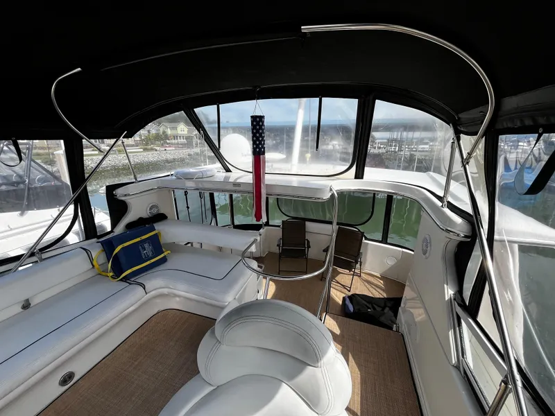 Slide: The Image of 2001 Sea Ray 420 Aft Cabin interior with seating, table, and American flag decor. - 23