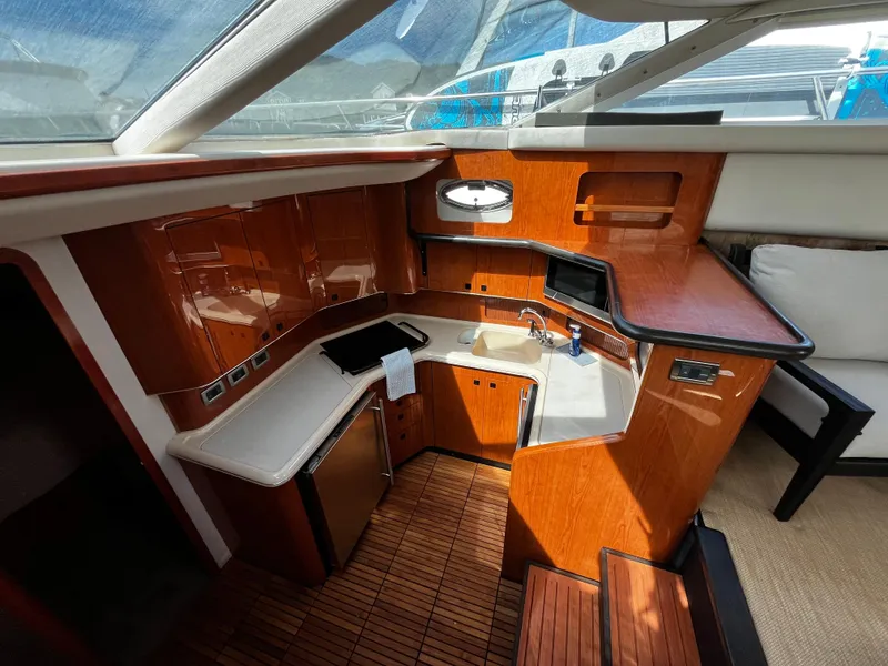 Slide: The Image of 2001 Sea Ray 420 Aft Cabin yacht interior with wood cabinetry and compact kitchen area. - 32