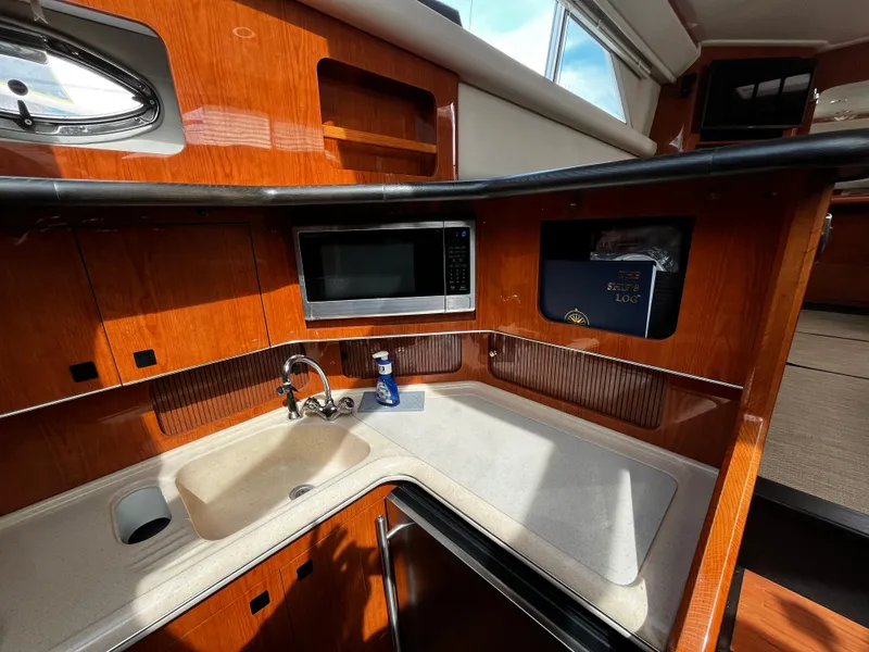 Slide: The Image of 2001 Sea Ray 420 Aft Cabin kitchen with wood cabinetry and modern appliances. - 34