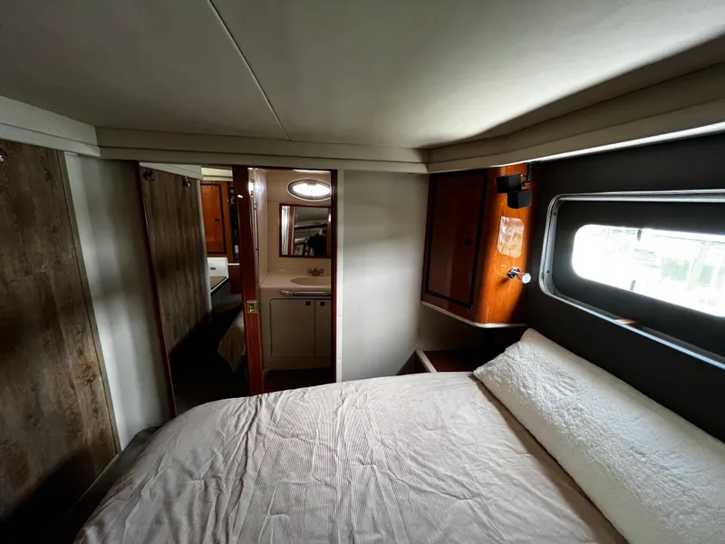 Slide: The Image of 2001 Sea Ray 420 Aft Cabin interior with bed, window, and bathroom view. - 46