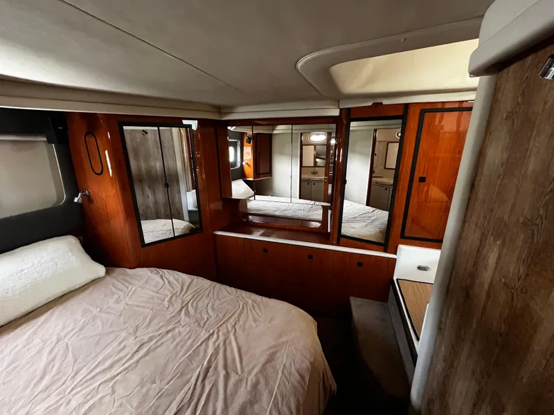Slide: The Image of 2001 Sea Ray 420 Aft Cabin interior with cozy bedroom and wooden accents. - 47