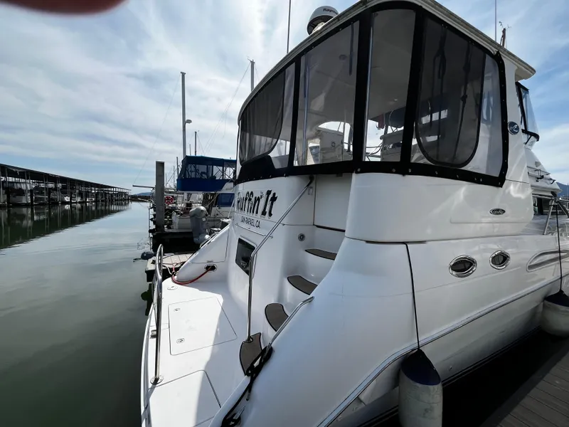 Slide: The Image of 2001 Sea Ray 420 Aft Cabin yacht docked at marina under cloudy sky. - 8