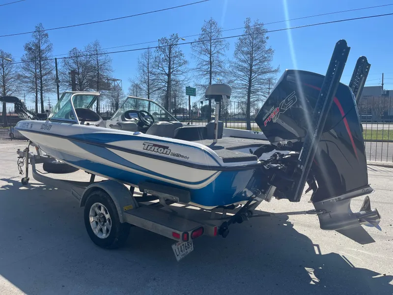 Slide: The Image of 2007 Triton 190 FS boat on trailer, blue and white, with powerful outboard motor. - 6