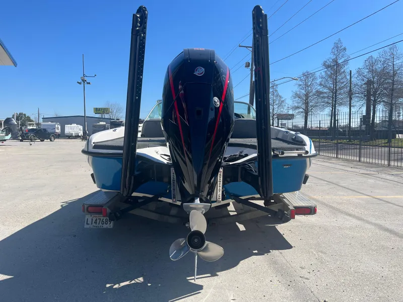Slide: The Image of 2007 Triton 190 FS boat with outboard motor, parked on a trailer in a sunny lot. - 7