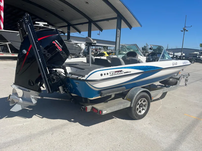 Slide: The Image of 2007 Triton 190 FS boat on trailer, parked outdoors under a canopy. - 8