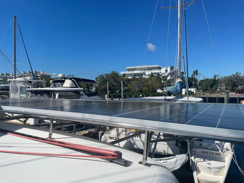 Slide: The Image of 2017 Lagoon 39 catamaran with solar panels docked in a marina under clear blue skies. - 5