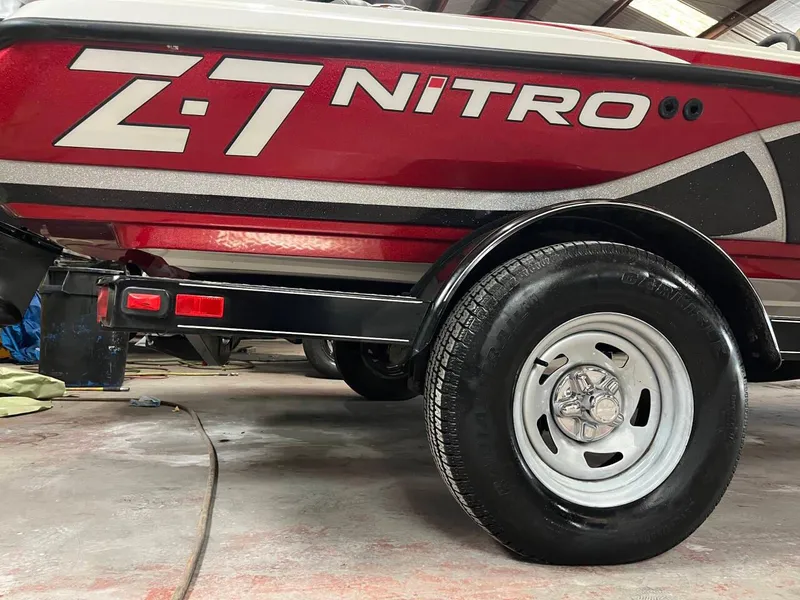 Slide: The Image of 2015 Nitro Z7 boat trailer with red and black design, featuring a visible wheel. - 18