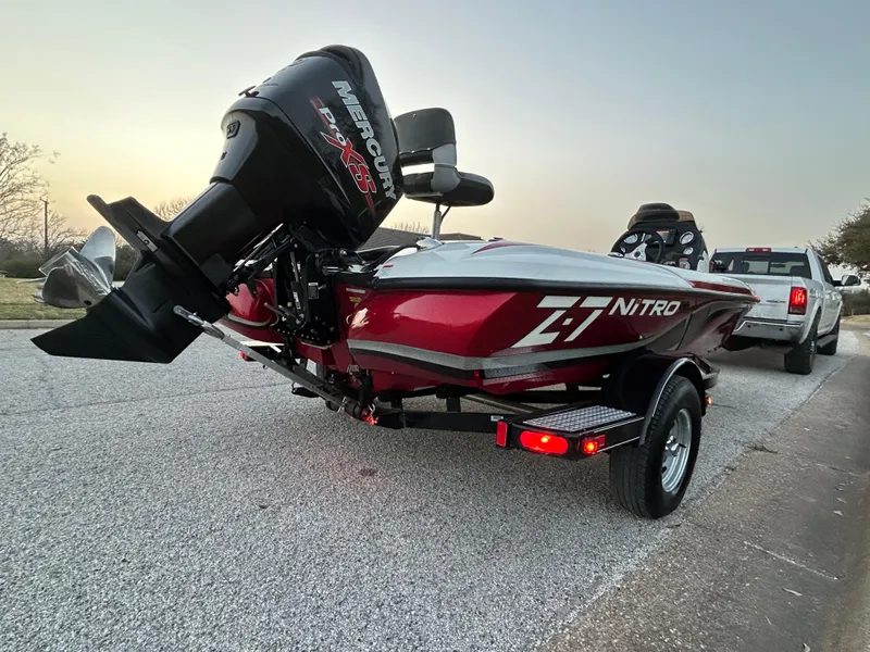 Slide: The Image of Red 2015 Nitro Z7 boat with Mercury engine on trailer, parked on road. - 27