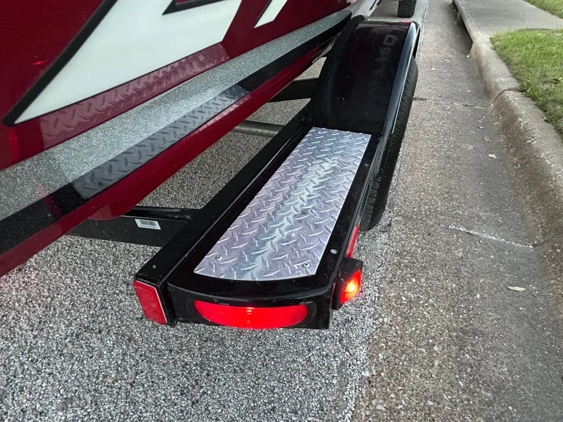 Slide: The Image of Trailer step of a 2015 Nitro Z7 boat with diamond plate design and red reflector. - 39