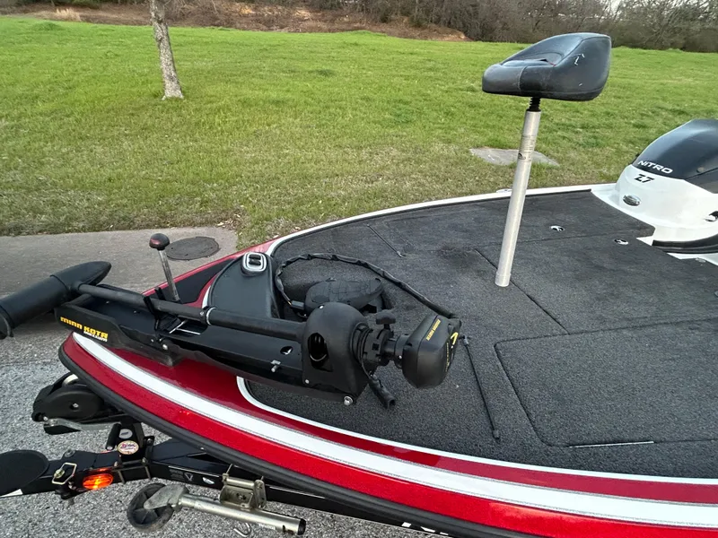Slide: The Image of 2015 Nitro Z7 boat deck with trolling motor and seat, parked on grass. - 49