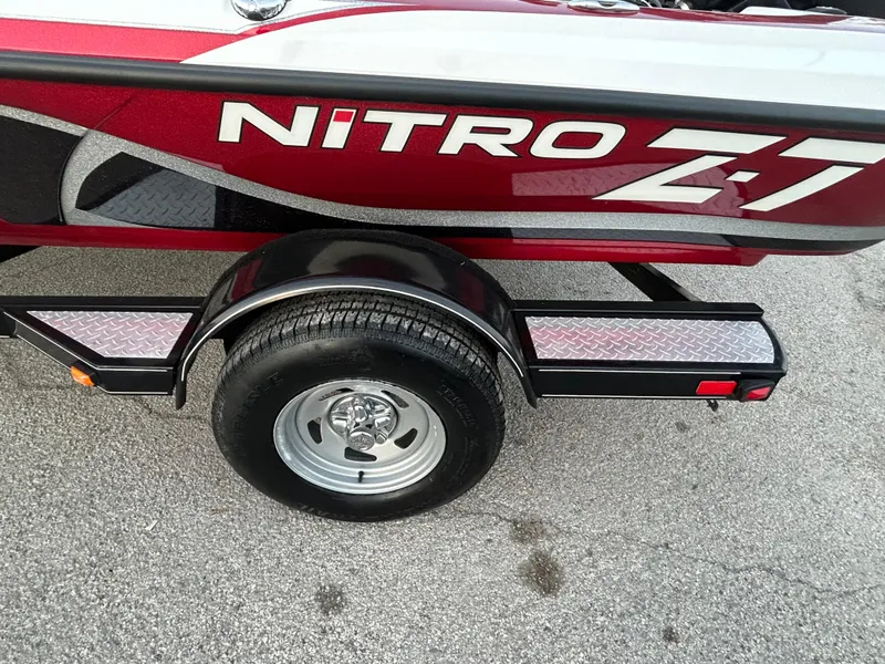 Slide: The Image of 2015 Nitro Z7 boat trailer with red and black design on pavement. - 52