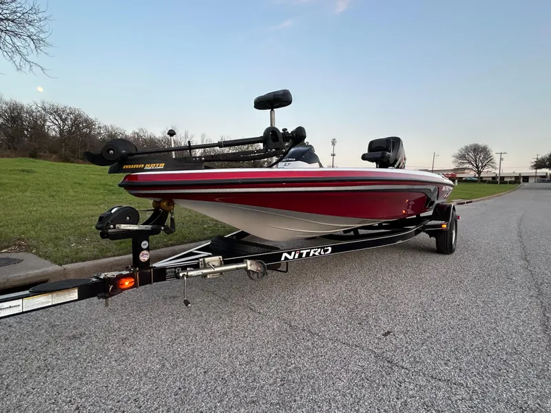 Slide: The Image of 2015 Nitro Z7 boat on trailer, parked on road, with green grass and trees in background. - 60