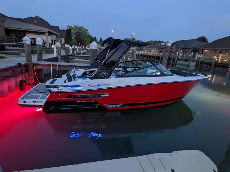 Slide: The Image of 2022 Monterey 258 Super Sport boat docked at marina during evening. - 2