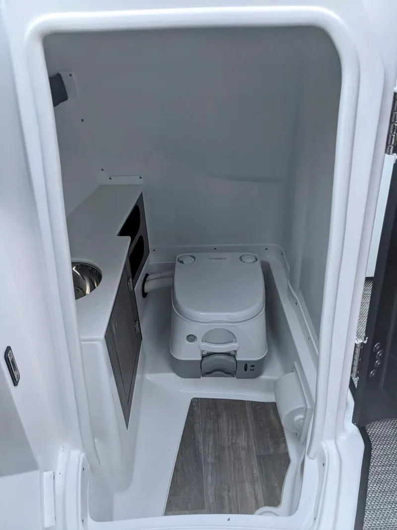Slide: The Image of 2022 Monterey 258 Super Sport boat interior with compact toilet and sink. - 21