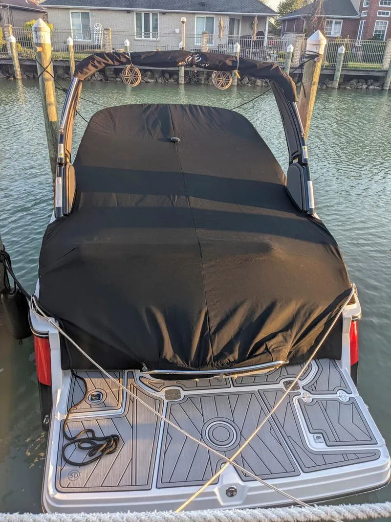 Slide: The Image of 2022 Monterey 258 Super Sport boat docked with black cover, rear view. - 22