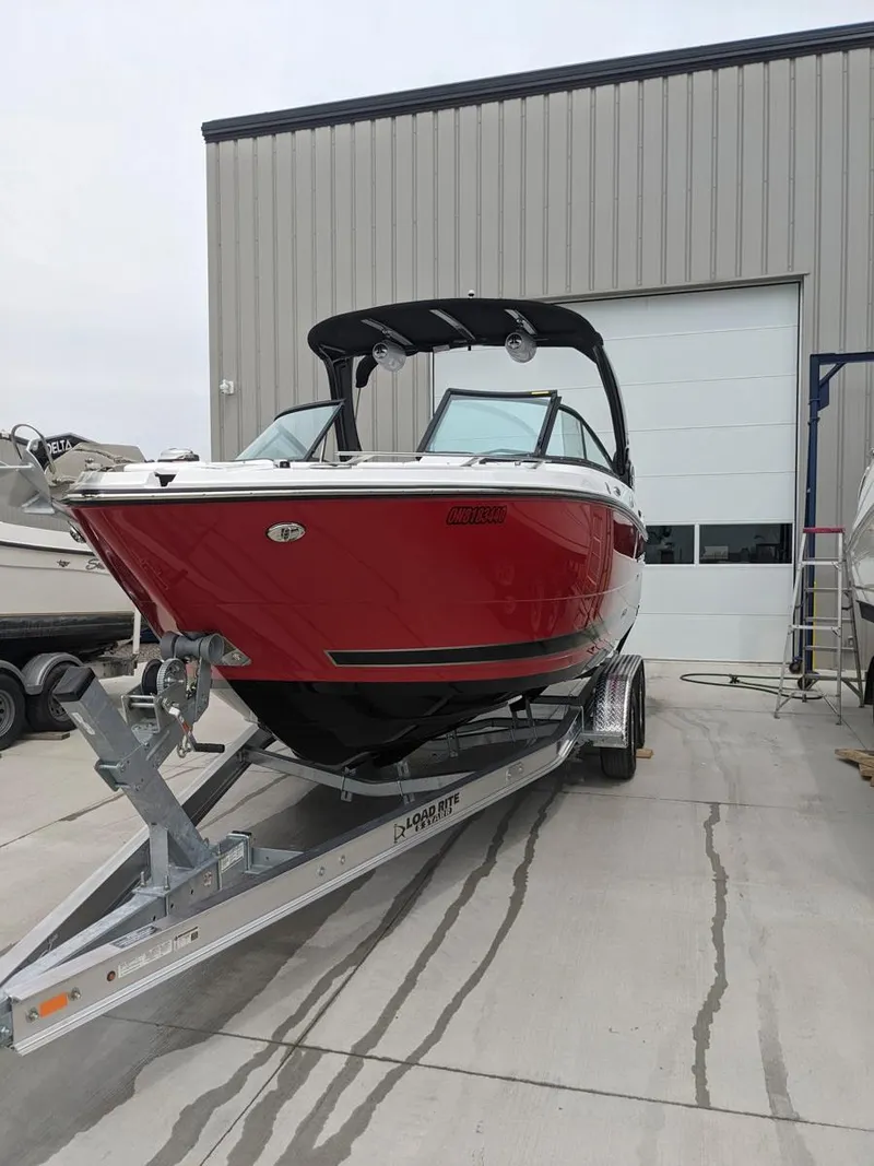 Slide: The Image of 2022 Monterey 258 Super Sport boat on trailer outside a warehouse. - 25