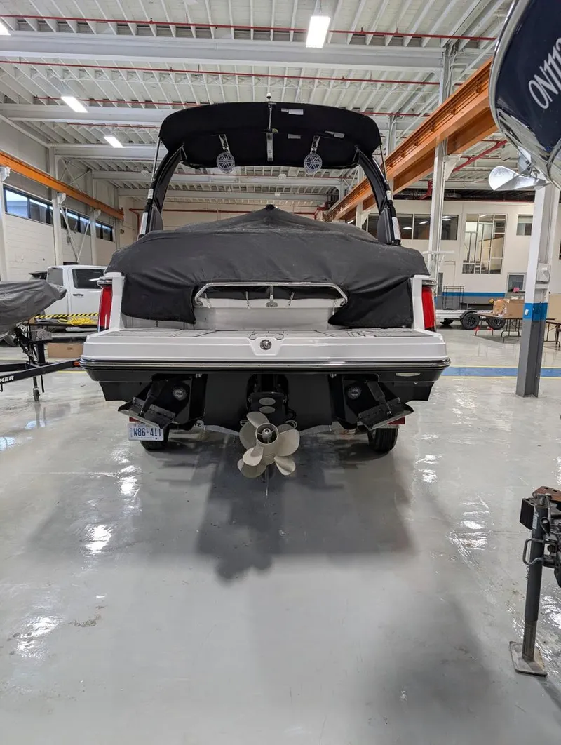 Slide: The Image of 2022 Monterey 258 Super Sport boat in a showroom, rear view with covered deck. - 29