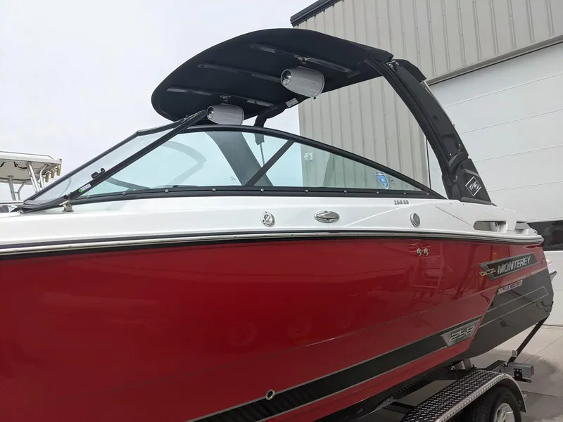 Slide: The Image of 2022 Monterey 258 Super Sport boat with red hull and sleek design. - 7