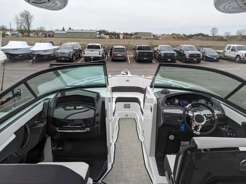 Slide: The Image of 2022 Monterey 258 Super Sport boat interior with dashboard and seating, parked in a lot. - 9