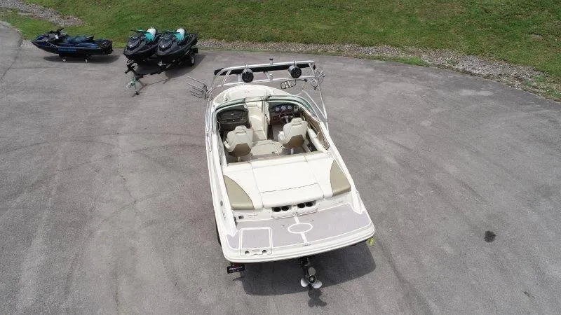 Slide: The Image of 2007 Sea Ray 210 Select boat parked on pavement, with jet skis in the background. - 12