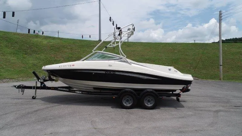Slide: The Image of 2007 Sea Ray 210 Select boat on trailer, parked outdoors under cloudy sky. - 17
