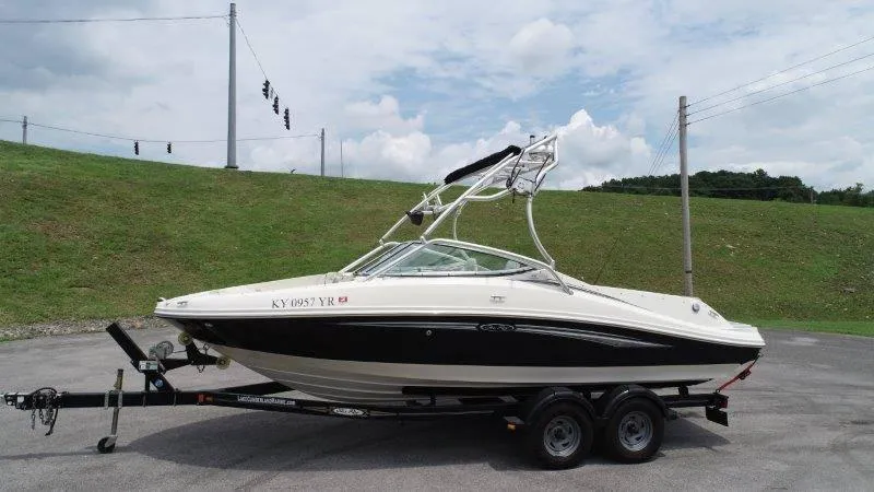 Slide: The Image of 2007 Sea Ray 210 Select boat on trailer, parked outdoors under cloudy sky. - 18