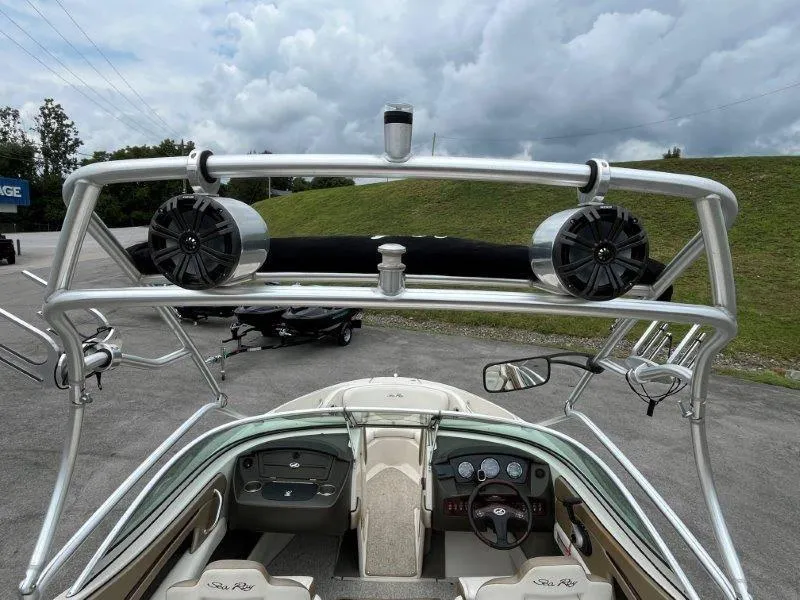 Slide: The Image of 2007 Sea Ray 210 Select boat interior with speakers and steering wheel, under cloudy sky. - 27