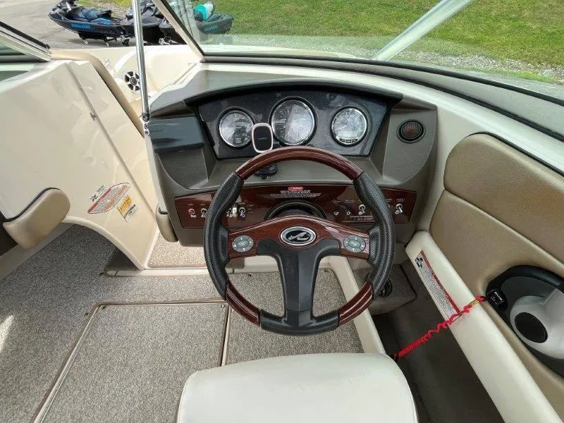Slide: The Image of 2007 Sea Ray 210 Select boat dashboard with steering wheel and gauges. - 39